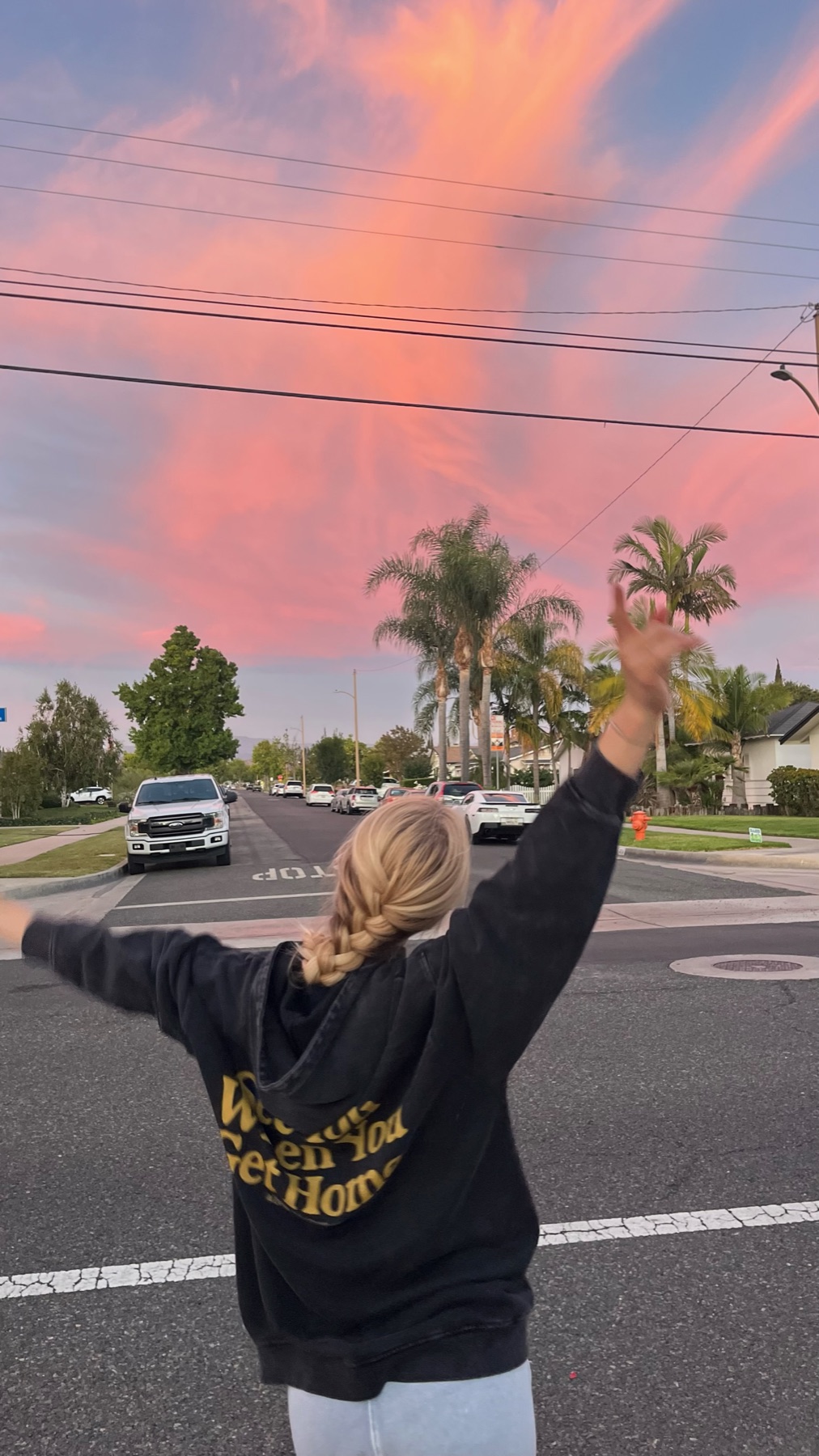 A crew member celebrating beneath a pink Southern California sunset